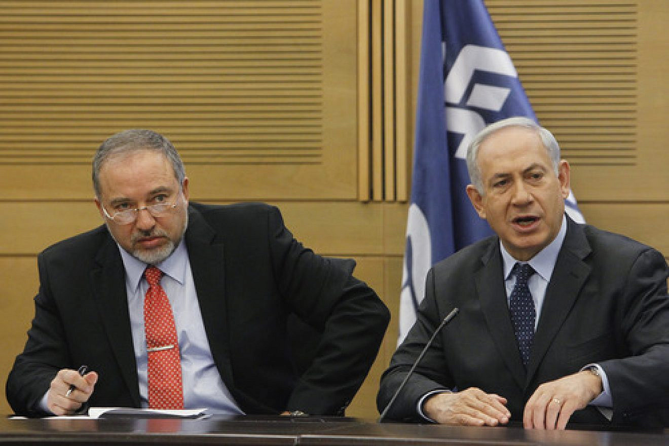 Israeli Prime Minister Benjamin Netanyahu (right) and then Foreign Minister Avigdor Lieberman at a meeting of the Likud-Beiteinu faction in the Knesset on March 11, 2014.