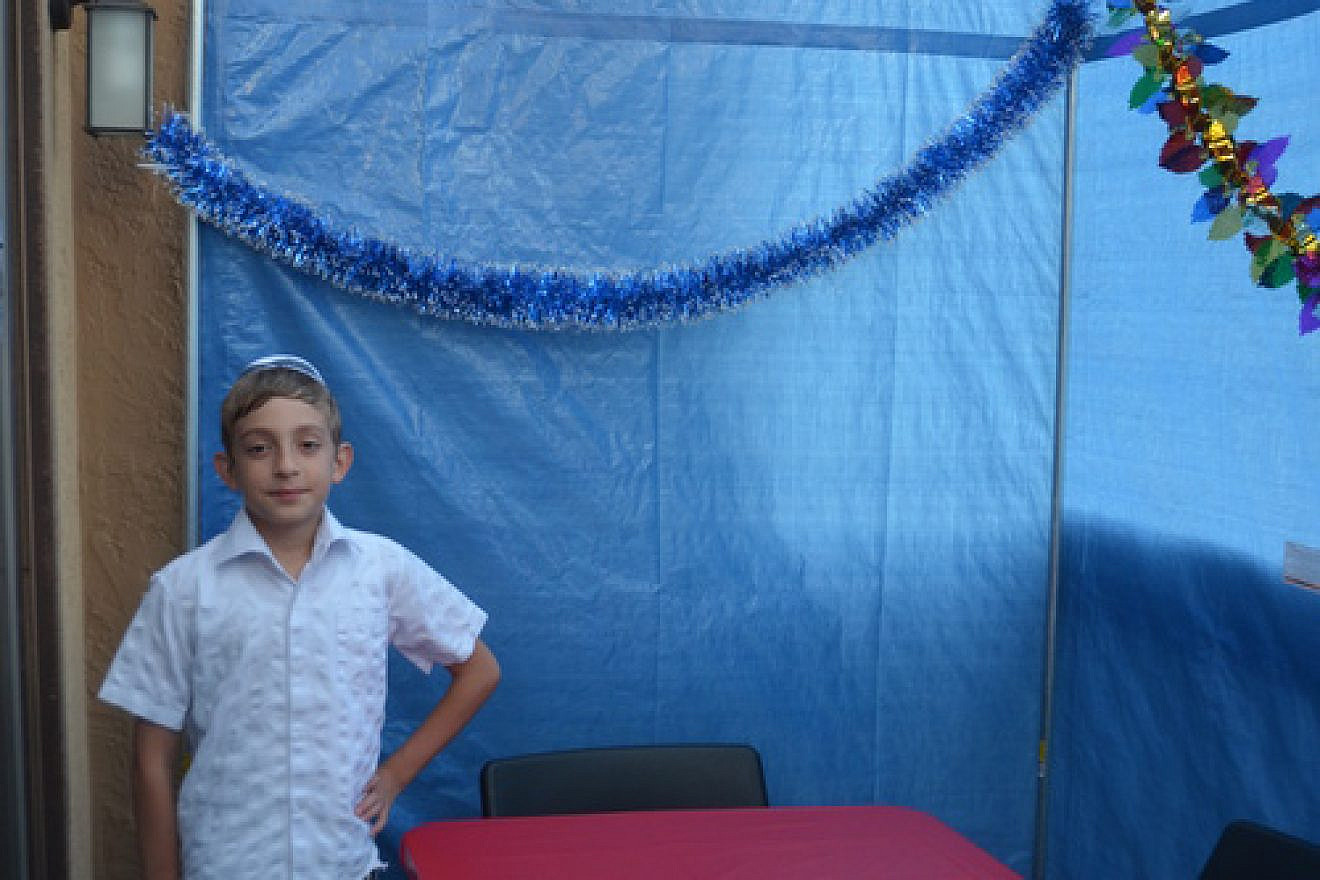Shai-El Luger and his single mother always wanted a sukkah of their own, but could not afford one. Dr. Jay Robinow changed that last year when he bought and built the Luger household's first sukkah (pictured). Credit: Courtesy.
