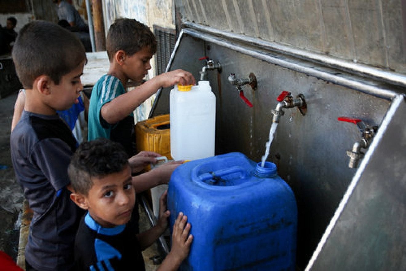 Palestinian children fill containers with drinking water from public taps in the southern Gaza Strip, June 11, 2017. Credit: Abed Rahim Khatib/Flash90.