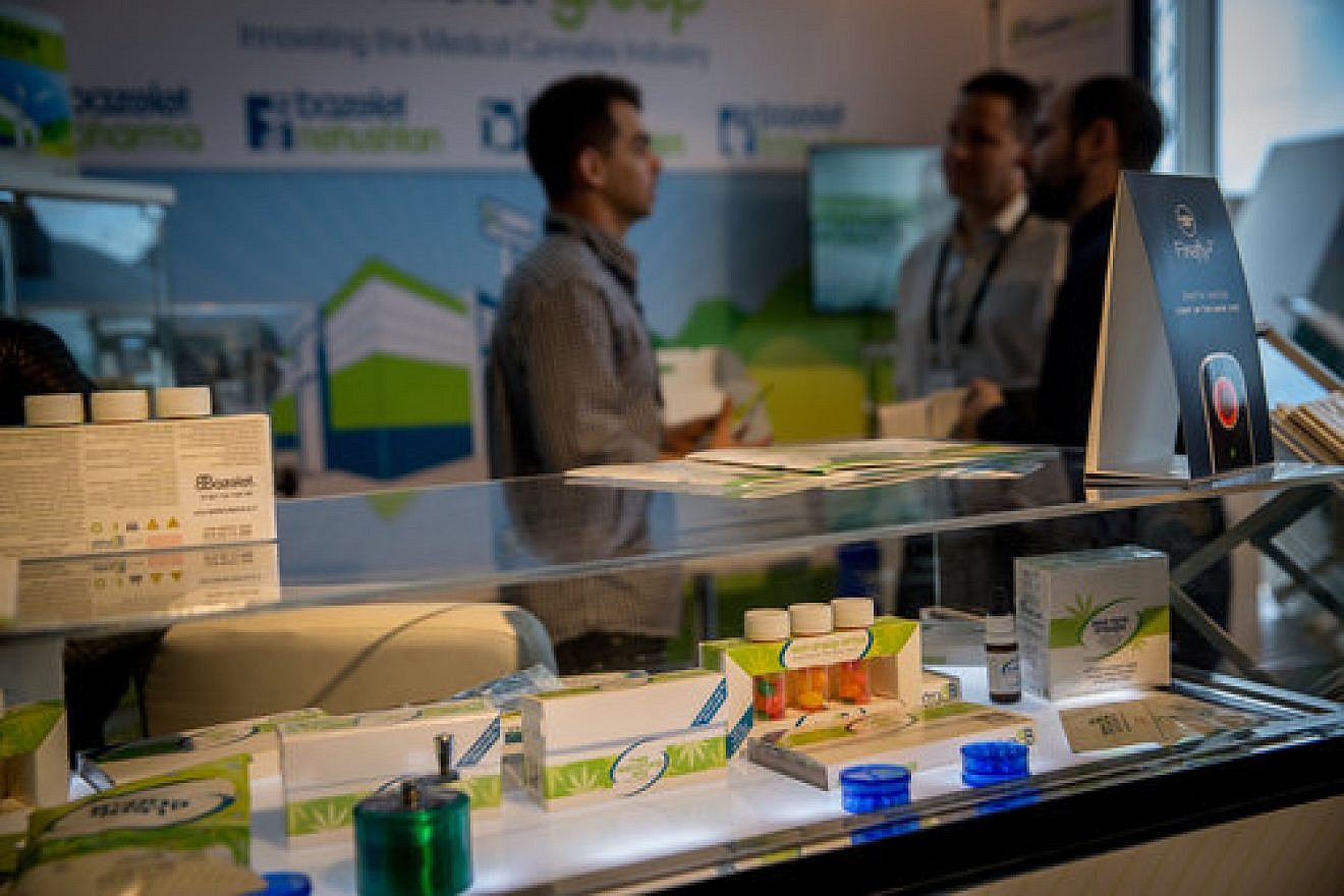 Inside the annual CannaTech medical marijuana innovation conference in Tel Aviv March 20, 2017. Moshe Ihea (in center), founder and CEO of Israel-based Cannabliss, discusses his company's cannabis-based medicines that are on display. Credit: Miriam Alster/Flash90.Credit: Miriam Alster/Flash90.