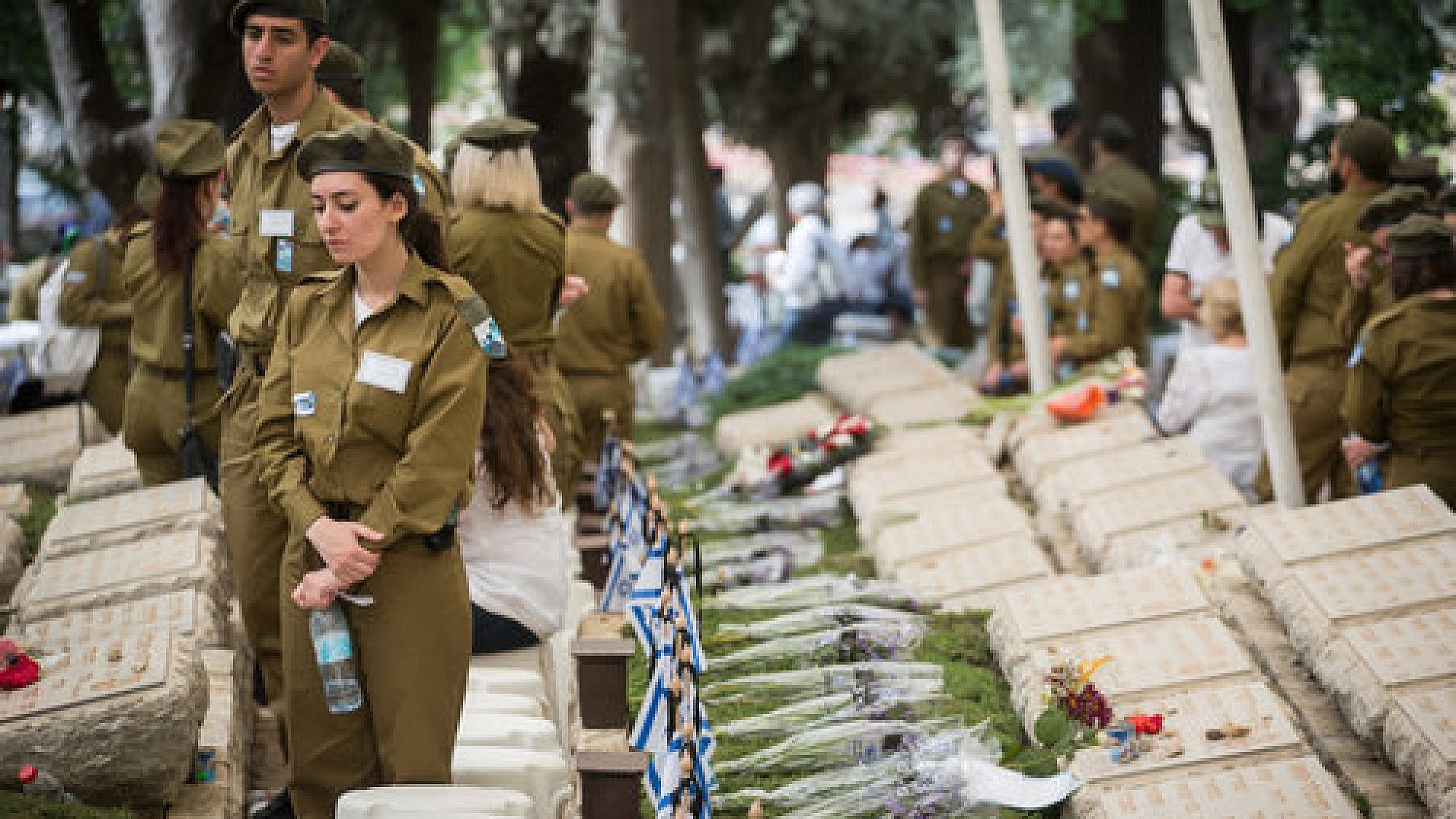 Israeli soldiers stand by the graves of the fallen at the Kiryat Anavim military cemetery on Yom Hazikaron (Memorial Day), on May 1, 2017. Credit: Hadas Parush/Flash90.