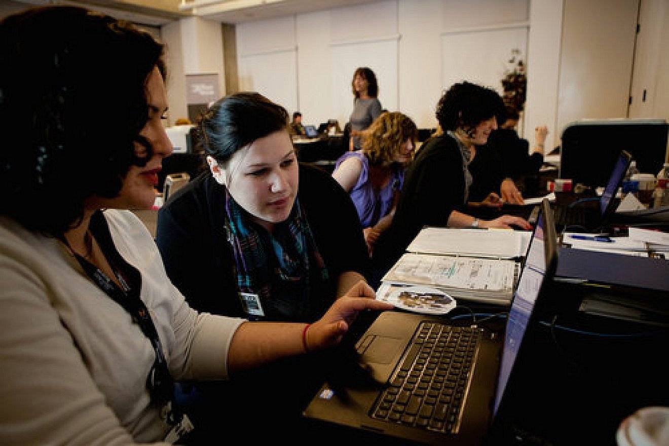 Sara-Joelle Clark (left), a U.S. Holocaust Memorial Museum researcher, shows documents she found in the International Tracing Service archive to Beckah Restivo, who was looking for information on her great-grandfather Felix. Credit: U.S. Holocaust Memorial Museum.