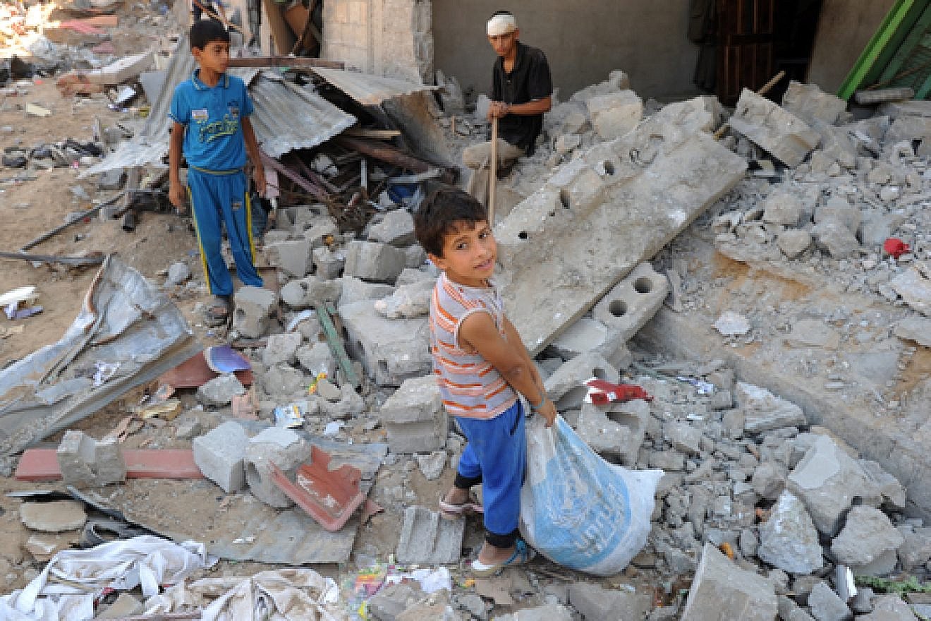 Palestinian youths search through rubble in the Gaza Strip in August 2014, during that summer's war between Israel and the Gaza-ruling Hamas terror group. Credit: UN Photo/Shareef Sarhan.