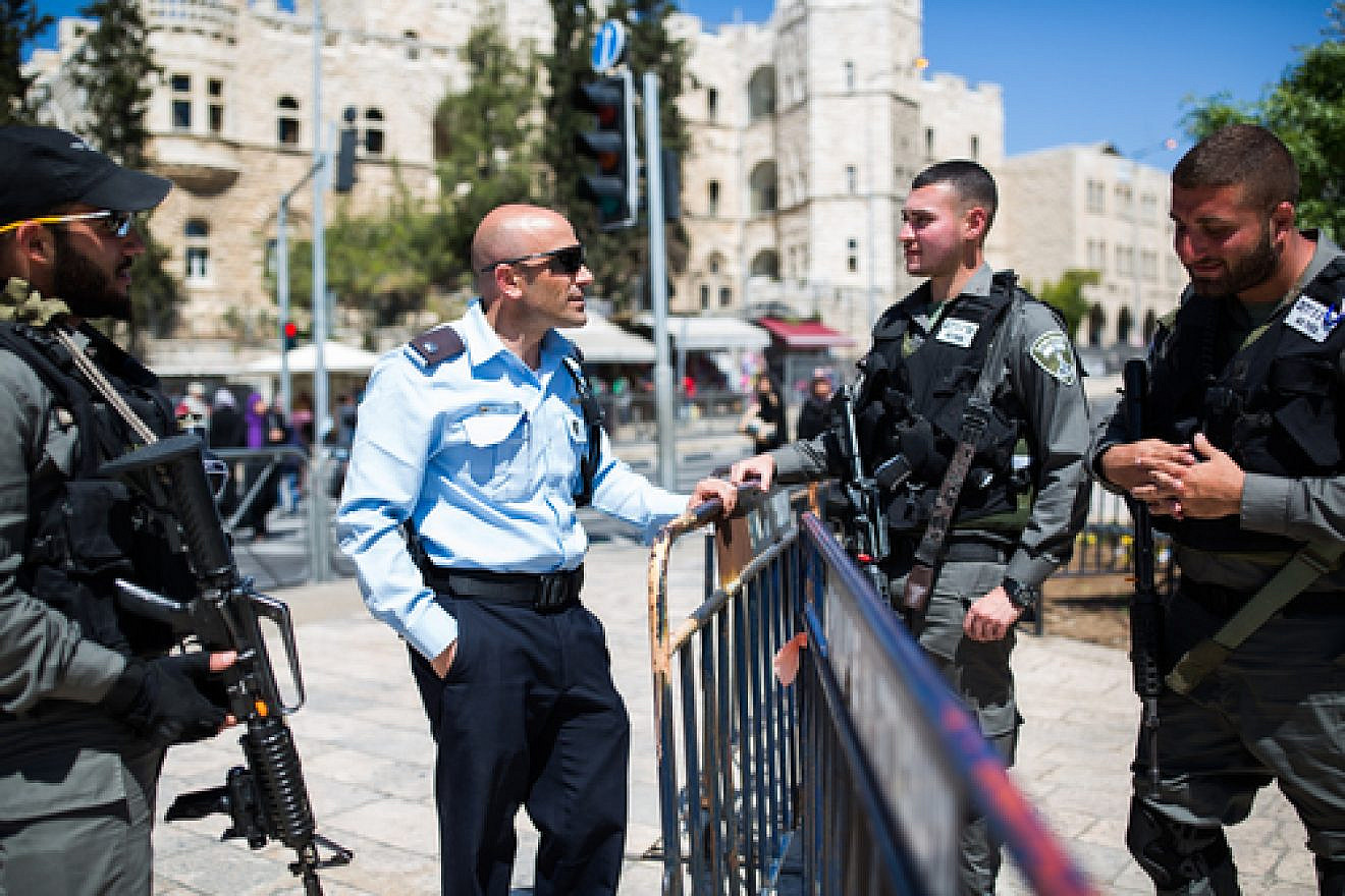Click photo to download. Caption: An Israeli policeman (second from left) speaks to Israeli soldiers guarding the stairs to the Damascus Gate in Jerusalem's Old City on March 23, 2016. Credit: Corinna Kern/Flash90.