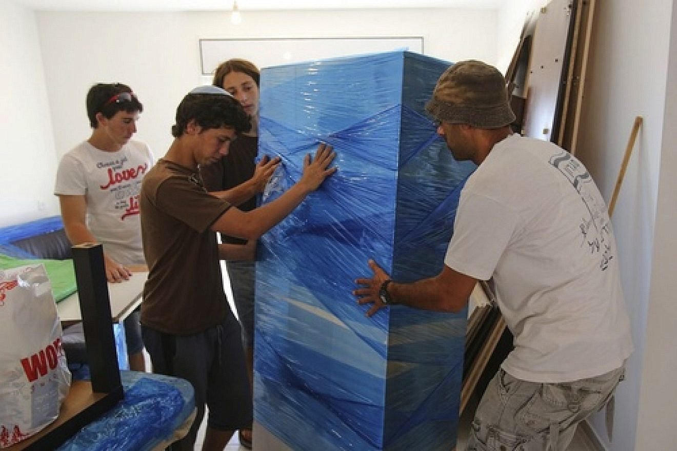 Click photo to download. Caption: Former Jewish residents of Migron, assisted by volunteers, move in to their new home of Givat Hayekev. Credit: Oren Nahshon/FLASH90.