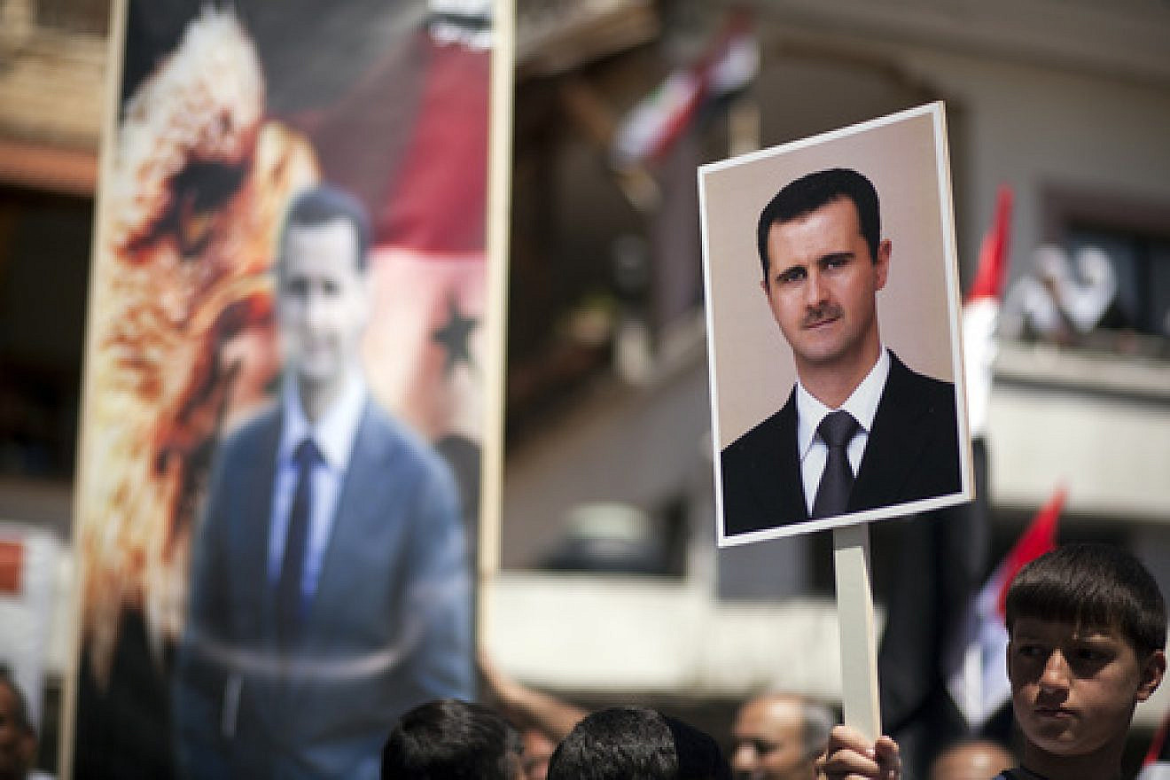 On April 17, 2012, Druze residents of Israel's Golan Heights hold Syrian flags and portraits of Syrian President Bashar Assad during a rally in the Druze village of Majdal Shams to mark the Syrian Independence Day. Credit: Matanya Tausig/Flash90.