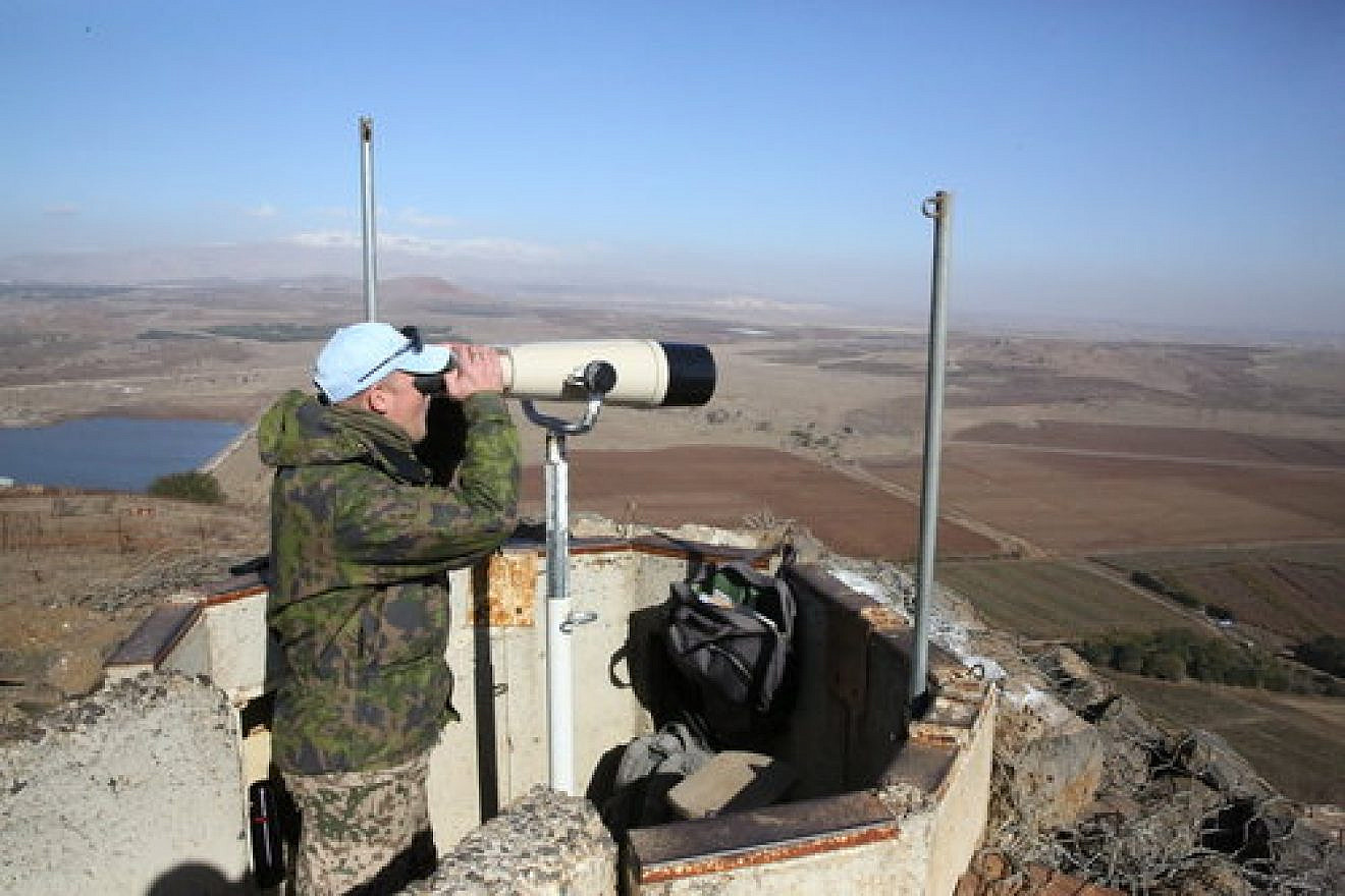 A United Nations observer looks through binoculars at a lookout point on Mount Bental in the Israeli Golan Heights, near the border with Syria, in December 2016. Credit: Yossi Zamir Flash90.