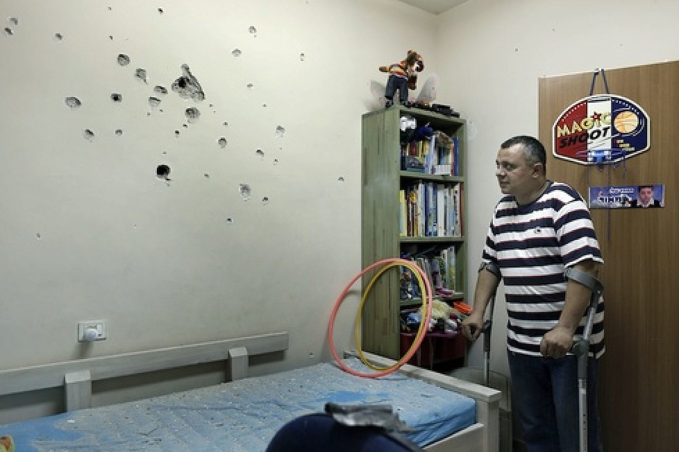 An Israeli man examine the damages from the shrapnel in a child's room after a long-range Grad rocket fired by Palestinian terrorists from the Gaza Strip landed in the backyard of a house in the southern Israeli town of Netivot, Friday, Oct. 12, 2012. Credit: Tsafrir Abayov/Flash90.
