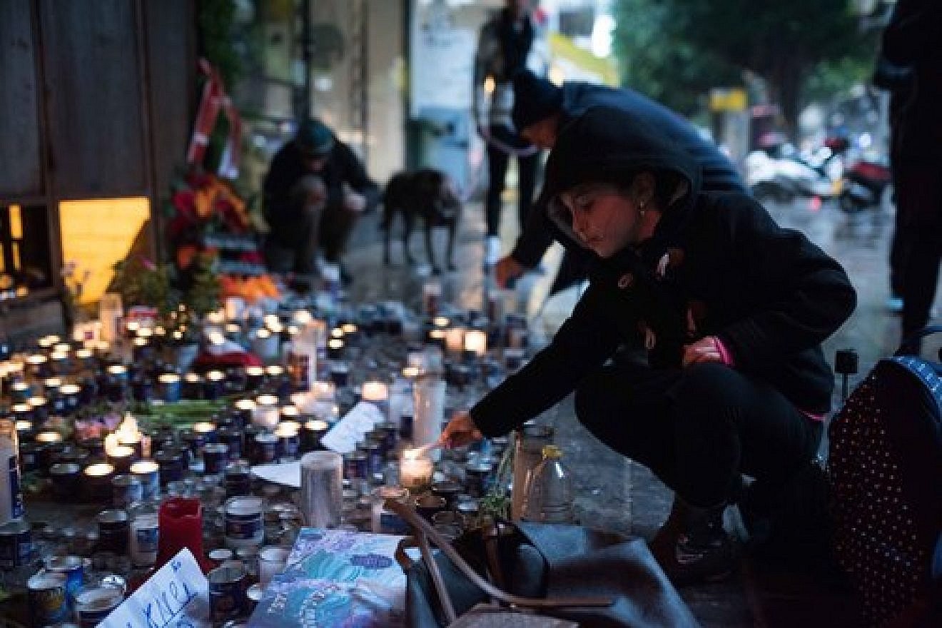 Israelis light memorial candles outside the Simta bar on Dizengoff Street in Tel Aviv on Jan. 3, 2016, two days after two Israeli Jews were killed at that bar in a shooting attack by a suspected Arab terrorist. Credit: Ben Kelmer/Flash90.