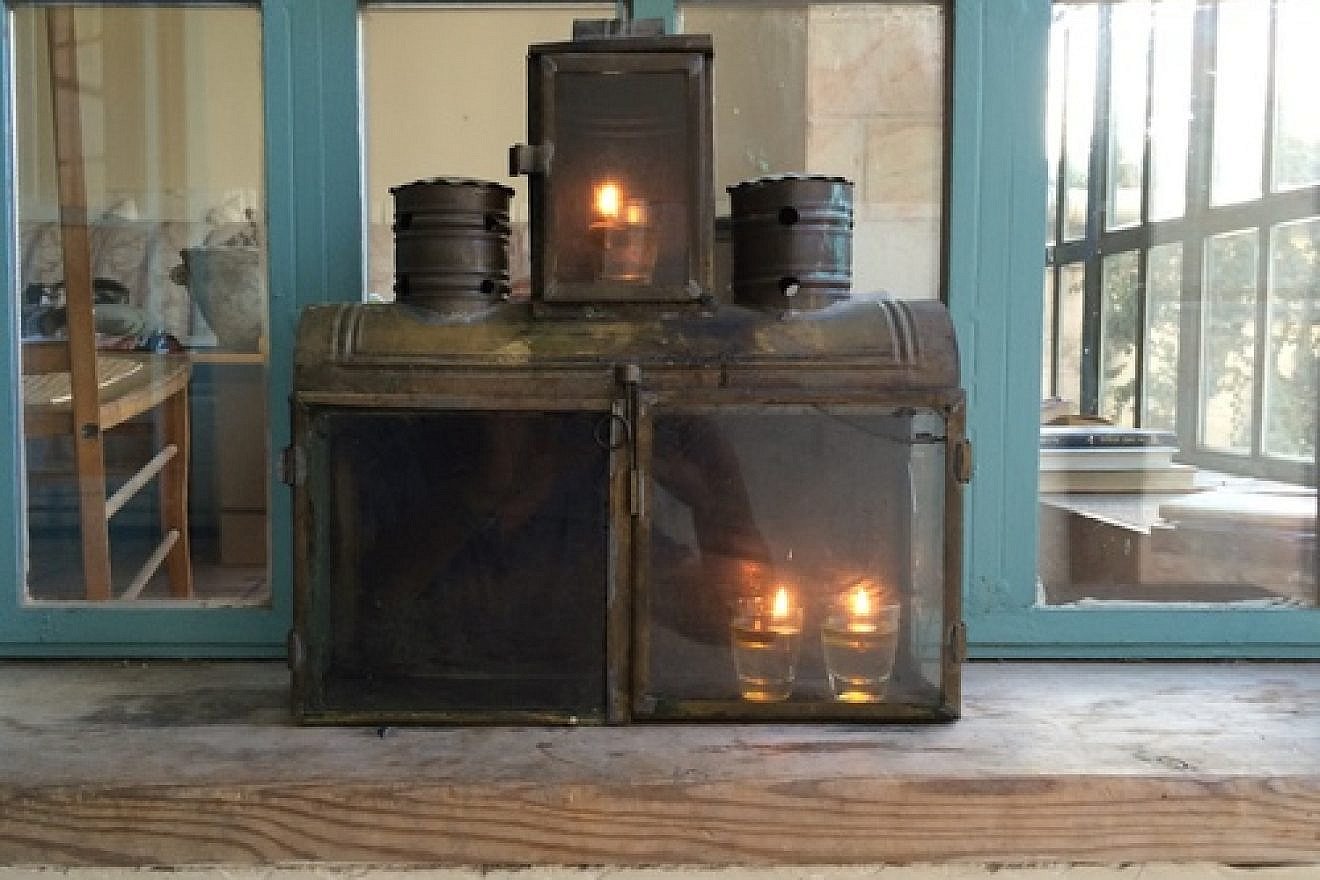 Yael Scalia Hershberg's Hanukkah menorah, in which nine shot glasses filled with olive oil (and each topped with a wick) are placed in a simple box fashioned of brass and tin. The box was purchased from a craftsman in the Jerusalem neighborhood of Mea Shearim. Credit: Yael Scalia Hershberg.