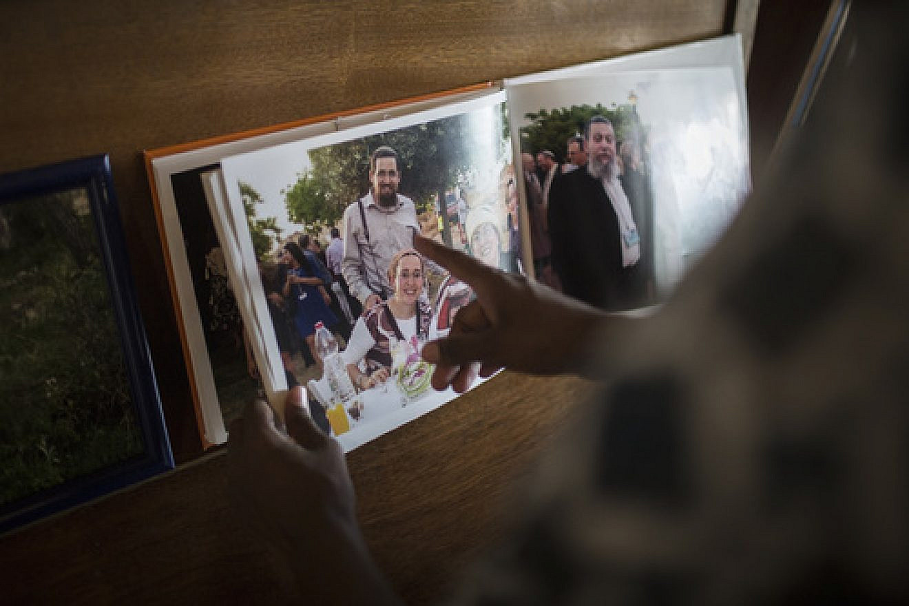 Last October in Jerusalem, friends and family members look at pictures of terror victims Rabbi Eitam and Naama Henkin during the shiva mourning period. The Henkins were shot dead by a Palestinian terrorist while the parents were driving with four of their children. The children survived the attack. Credit: Hadas Parush/Flash90.