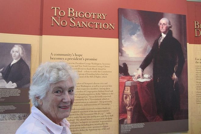 Rita Eisenberg Slom—a Newport, R.I., native who served as president of the historic Touro Synagogue from 1999-2001—is pictured in the Ambassador John L. Loeb Jr. Visitors Center next to a poster of the famous letter President George Washington addressed “To the Hebrew Congregation in Newport Rhode Island,” which is read annually at Touro Synagogue. Credit: Paul Foer.