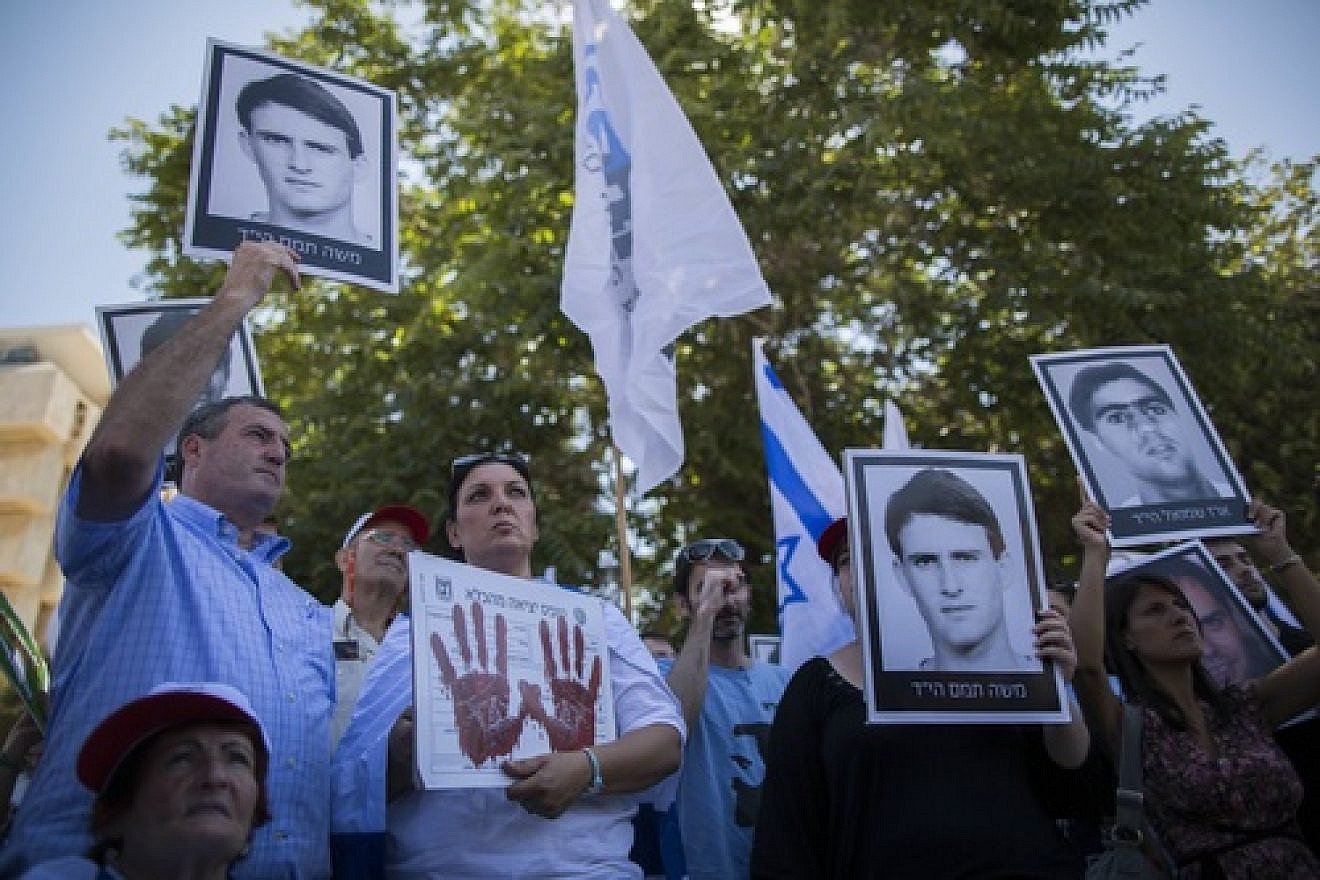 Click photo to download. Caption: On July 28, relatives of Israelis killed in terror attacks hold signs as they demonstrate outside of the Prime Minister's Office ahead of the Israeli cabinet vote on the proposal to free 104 terrorist prisoners for the restarting of Israel-Palestinian conflict talks. The prisoner release proposal passed in a 13-7 vote. Credit: Yonatan Sindel/Flash90.