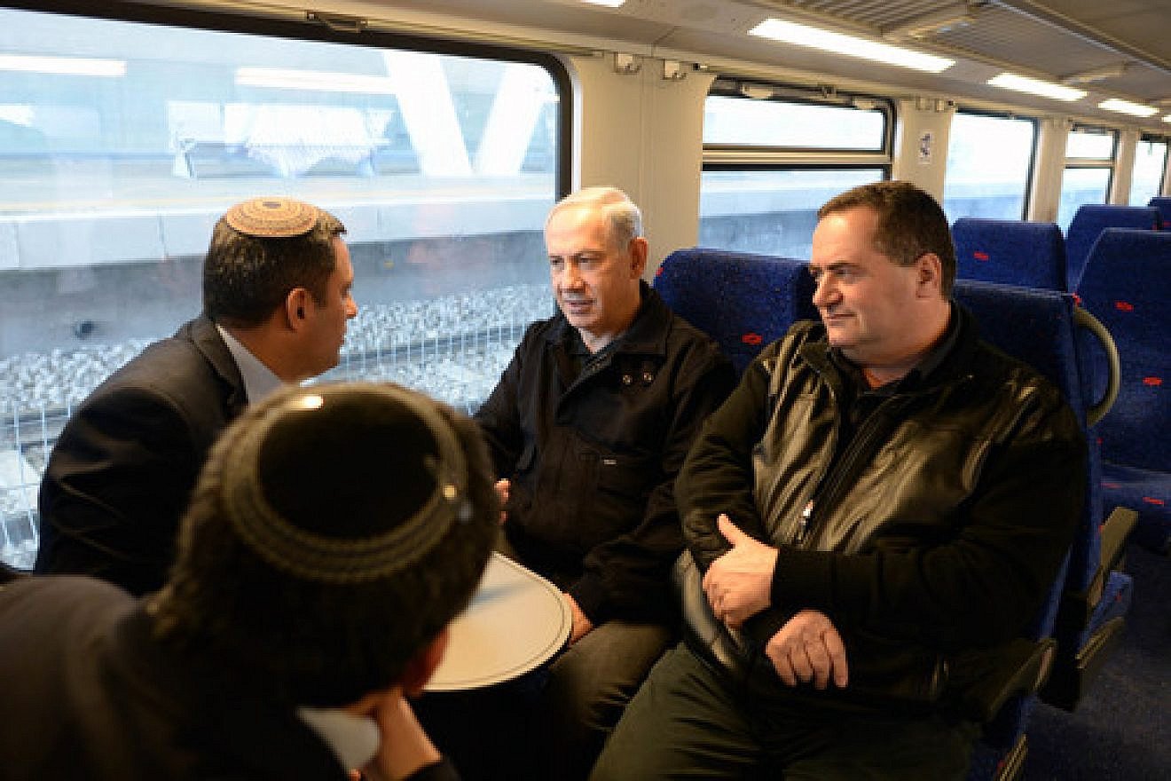 Israeli Prime Minister Benjamin Netanyahu and Israeli Minister of Transportation Yisrael Katz seen aboard a train in the southern Israeli town of Sderot, where they inaugurated a new rocket-proof train station, on Dec. 24, 2013. The new train line connects isolated Negev communities to larger Israeli population centers. Credit: Kobi Gideon/GPO/Flash90.