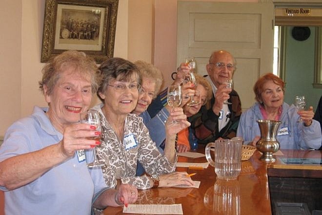 Community members make a toast at the St. Louis NORC ( Naturally Occurring Retirement Community). A group of Jewish federations started NORC communities in response to a federal initiative to develop replicable models to deal with the coming increase in the senior population. Credit: St. Louis NORC.
