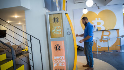 A man uses a bitcoin ATM machine at the Bitcoin Change center on Dizengoff Street in Tel Aviv on Nov. 5, 2023. Credit: Miriam Alster/Flash90.
