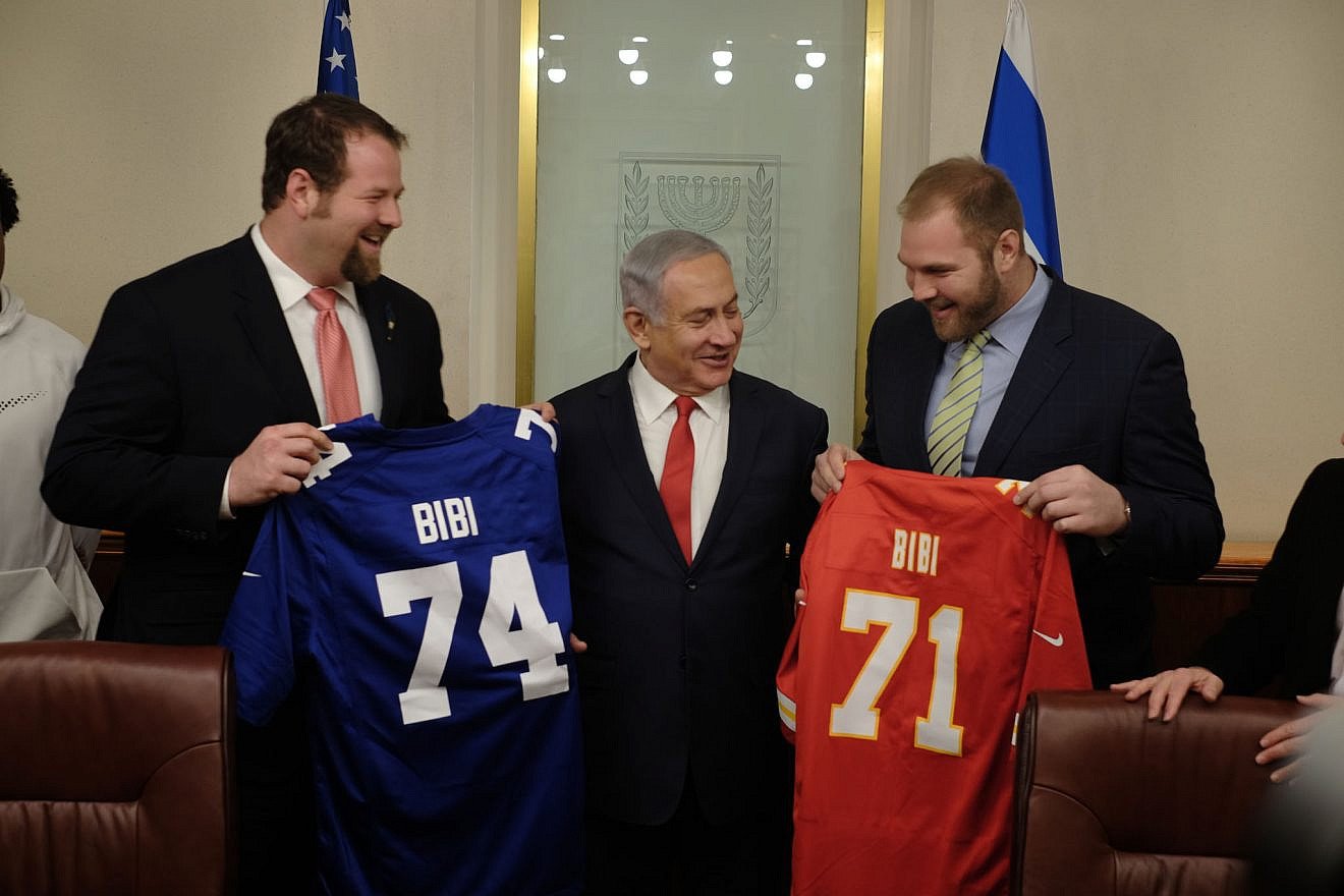 Jewish NFL football players and brothers Geoff (left) and Mitchell Schwartz present Israeli Prime Minister Benjamin Netanyahu with football jerseys that have his nickname, "Bibi," on them in his Jerusalem office on Feb. 19, 2018. (Judah Ari Gross/Times of Israel)