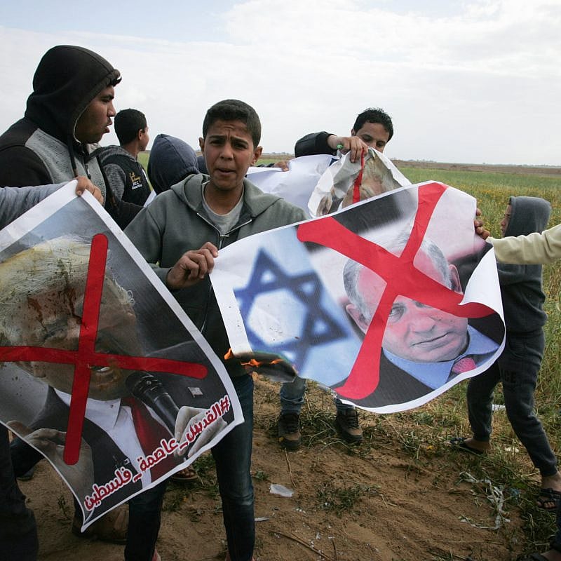 Palestinians demonstrate with posters marring the images of Israeli Prime Minister Benjamin Netanyahu and U.S. President Donald Trump during a protest near Khan Yunis in the southern Gaza Strip on March 30, 2018. Credit: Abed Rahim Khatib/Flash90