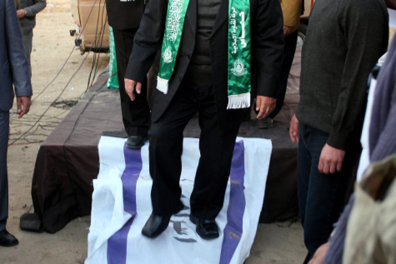 Hamas leader Mahmud al-Zahar steps on an Israeli flag, with Arabic scrawled on it, as part of celebrations in Gaza City marking the 23rd anniversary of the terror group’s founding, Dec. 9, 2010. Photo by Mohammed Othman/Flash90.