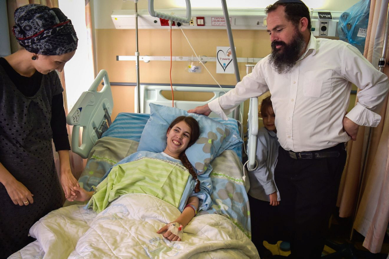Shuva Malka, the 18-year-old woman who was stabbed and seriously wounded in a terror attck last week, is seen at HaEmek Medical Center in Afula with relatives on June 17, 2018. Photo by Meir Vaknin/Flash90.