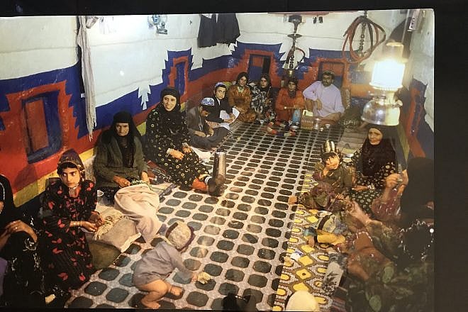 A Yemenite Jewish family in the multifunction room of their home, which would be used for sleeping, eating and entertaining. Photo from a 2018 exhibit in New York City. Credit: Shiryn Solny/JNS.