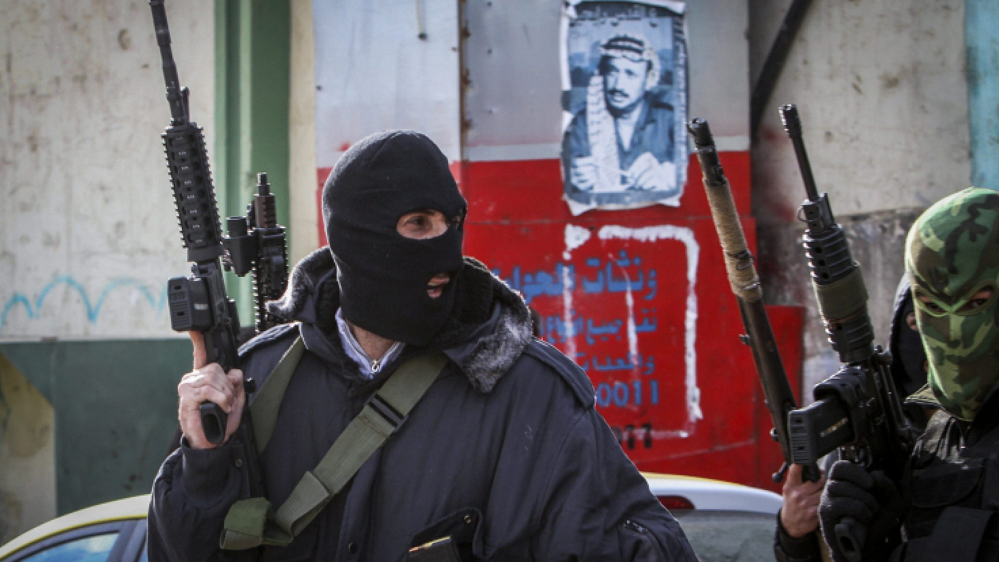 Masked Palestinian militants from the Al-Aqsa Martyrs Brigade, an armed wing linked to Fatah, hold up weapons near Nablus, Jan. 10, 2017.  Photo by Nasser Ishtayeh/Flash90.