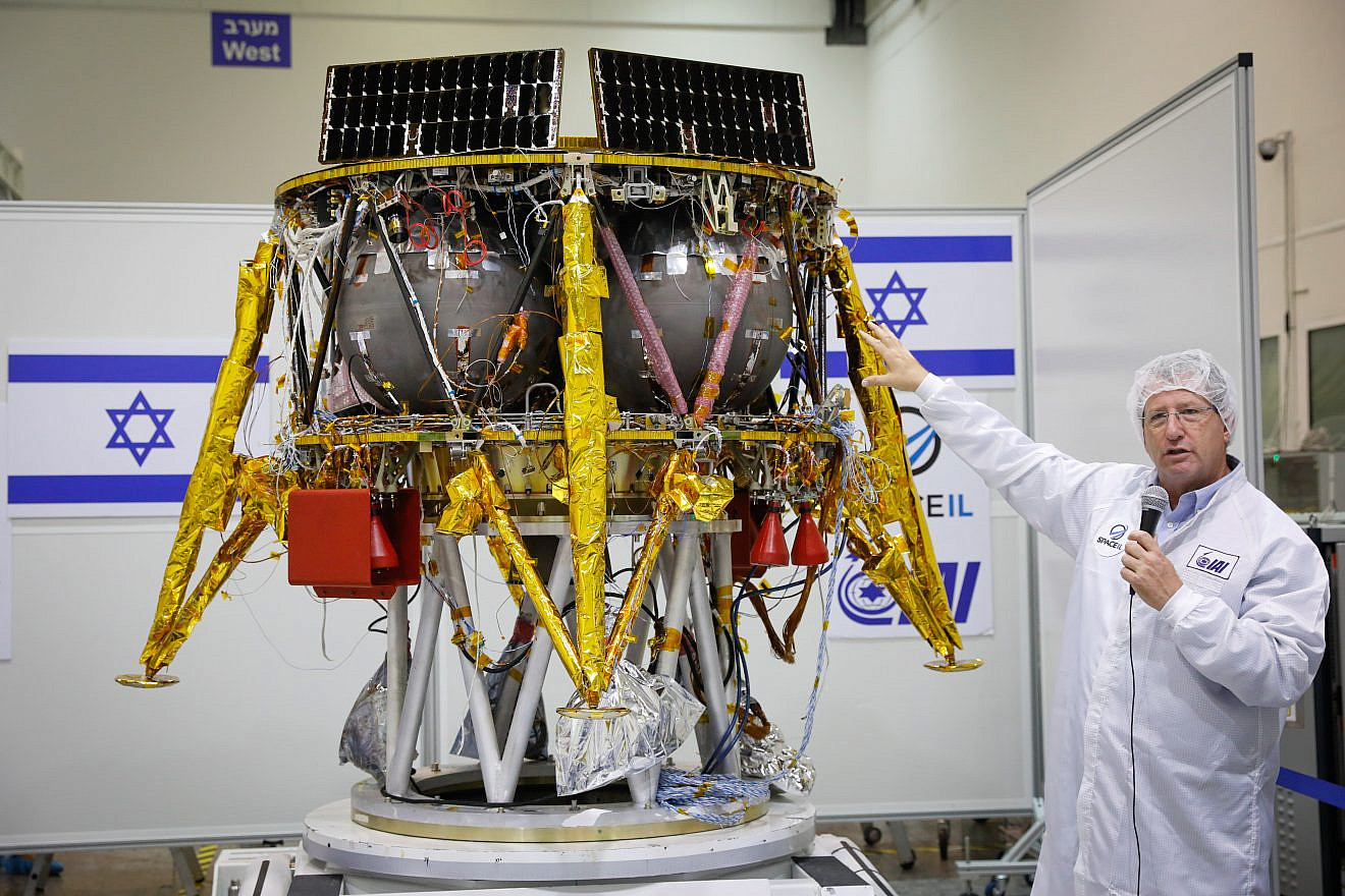 Ofer Doron, head of IAI's MBT Space Division speaks near the Israeli spacecraft of the SpaceIL team's spacecraft, during a press conference at the Israel Aerospace facility in Yahud on July 10, 2018. Photo by Flash90.