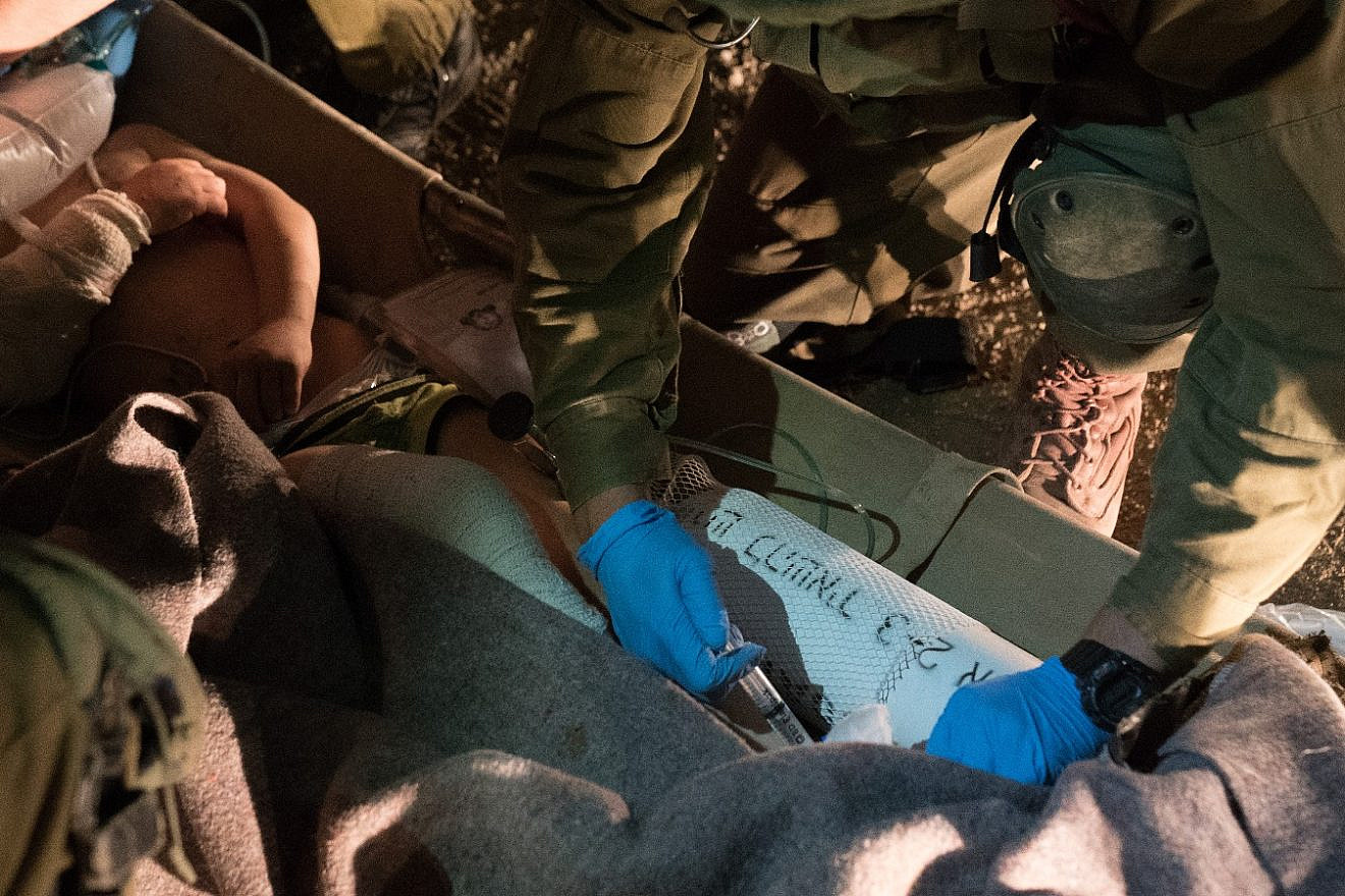 Israel Defense Forces soldiers providing emergency medical care to young Syrians injured in attacks by Syrian President Bashar Assad on rebel-held towns near Daraa, prior to evacuating them to Israel. Source: IDF Spokesperson's Unit.