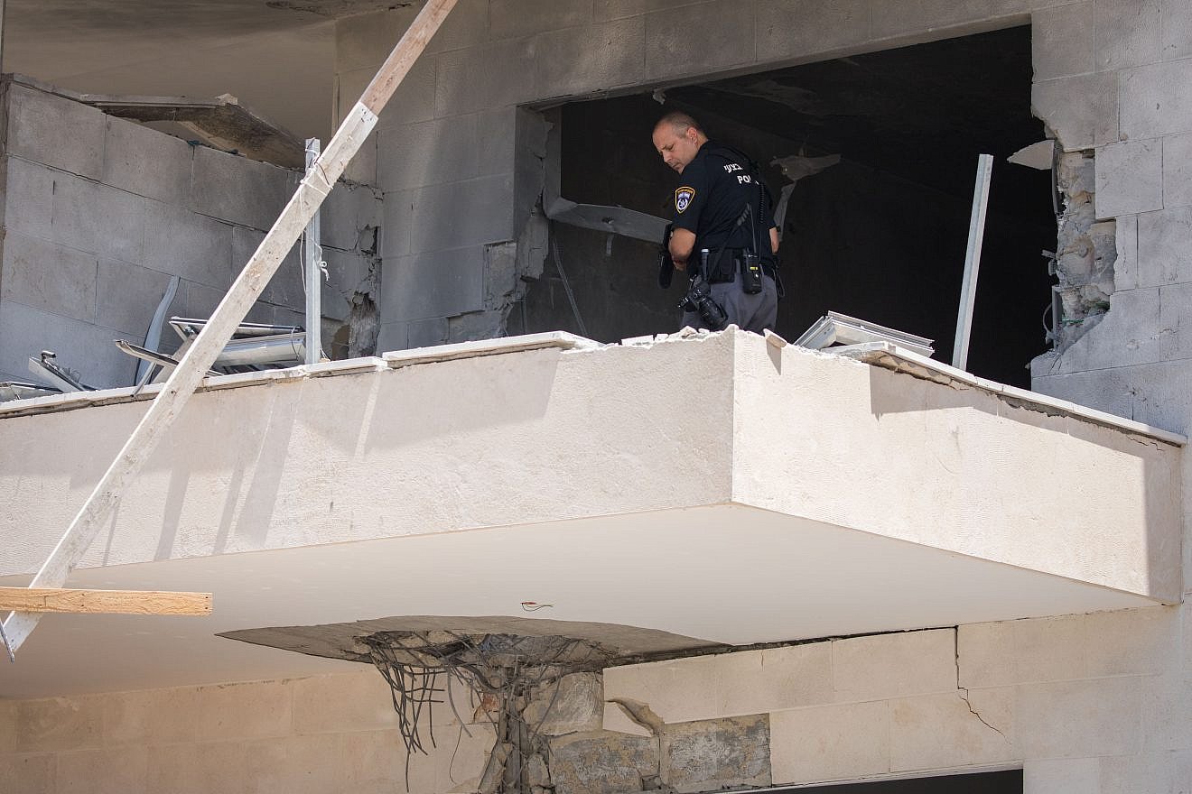 An Israeli police officer examines where a mortar shell from Gaza hit a construction site in the southern Israeli city of Sderot, near the border with Gaza on Aug. 9, 2018. Photo by Yonatan Sindel/Flash90.