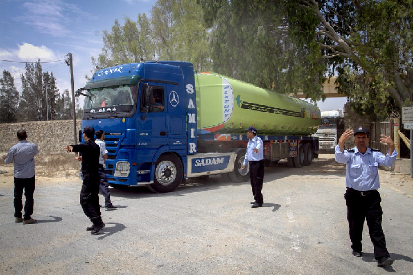 Palestinian security forces stand guard as Egyptian trucks carrying fuel drive down a street after entering the southern Gaza Strip from Egypt through the Rafah border crossing on June 21, 2017. Photo by Abed Rahim Khatib/Flash 90.