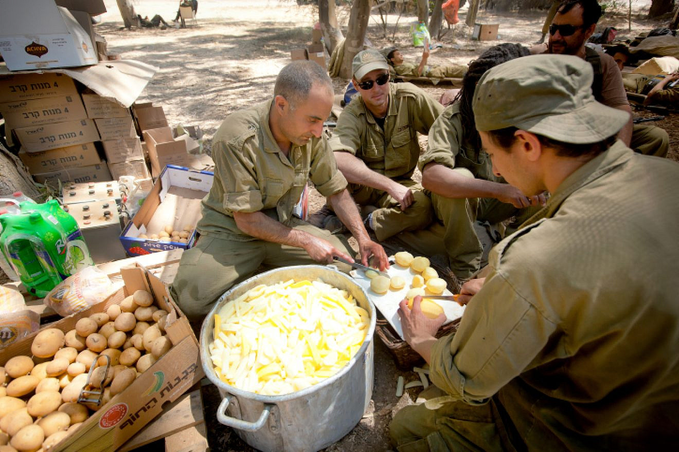 IDF reserve soldiers seen making food in a staging area near the border with Gaza in southern Israel on July 20, 2014, during Israel's “Operation Protective Edge.” Photo by Moshe Shai/Flash90.