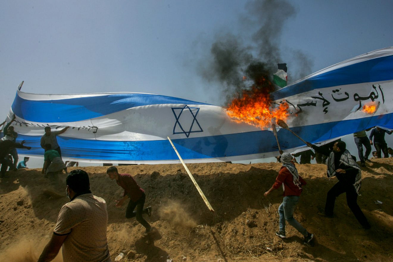 Palestinians protesters burn a a giant Israeli flag during clashes with Israeli security forces on the Gaza Israeli border east of Khan Yunis, in the southern Gaza Strip on April 6, 2018. Photo by Abed Rahim Khatib/Flash90.