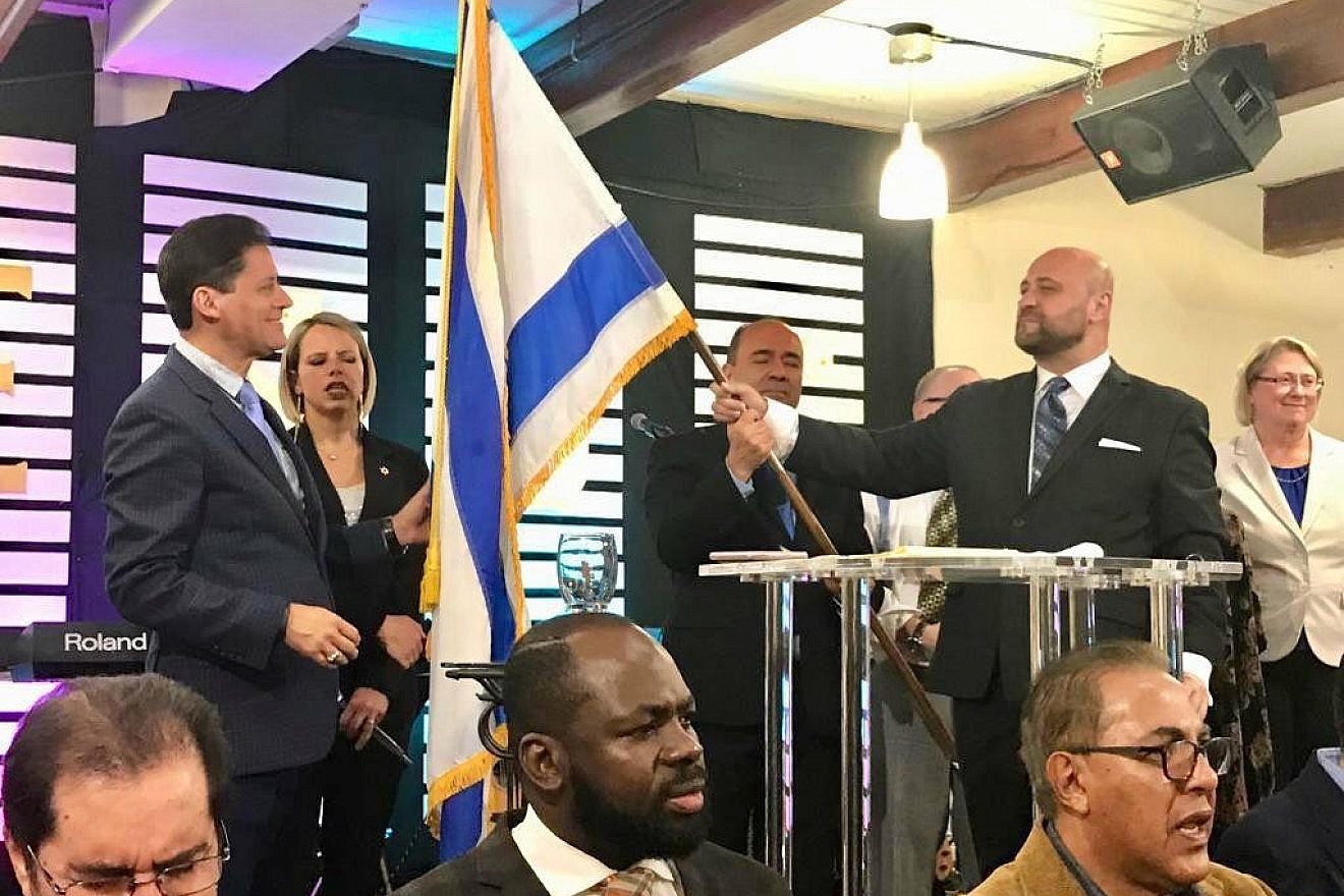 Pastors Josimar Salum and Robert Stearns holding the Israeli flag at a recent CAMERA event.