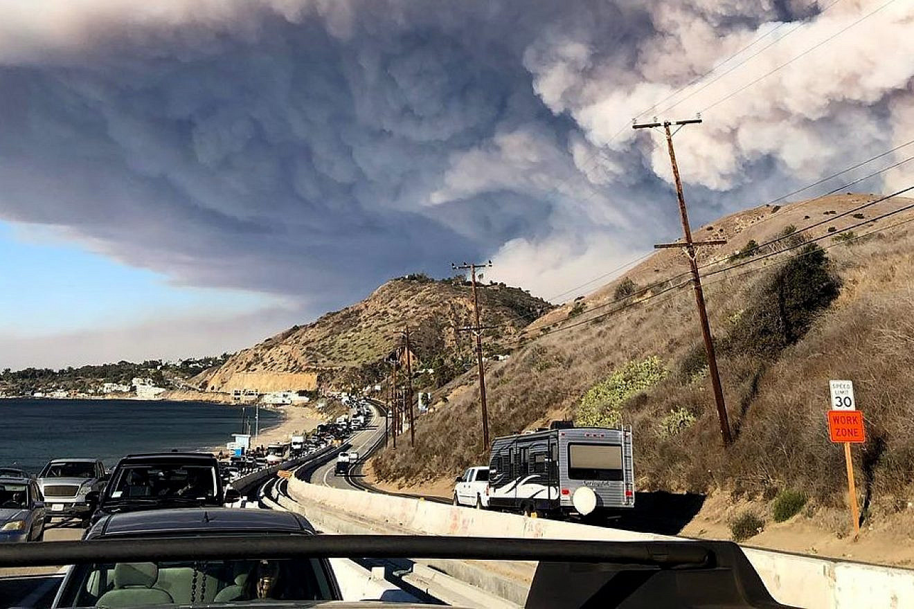 The smoke plume from the fast-moving Woolsey Fire encroaching on Malibu, Calif., on Nov. 9, 2018, as residents evacuate along the Pacific Coast Highway. Credit: Wikimedia Commons.