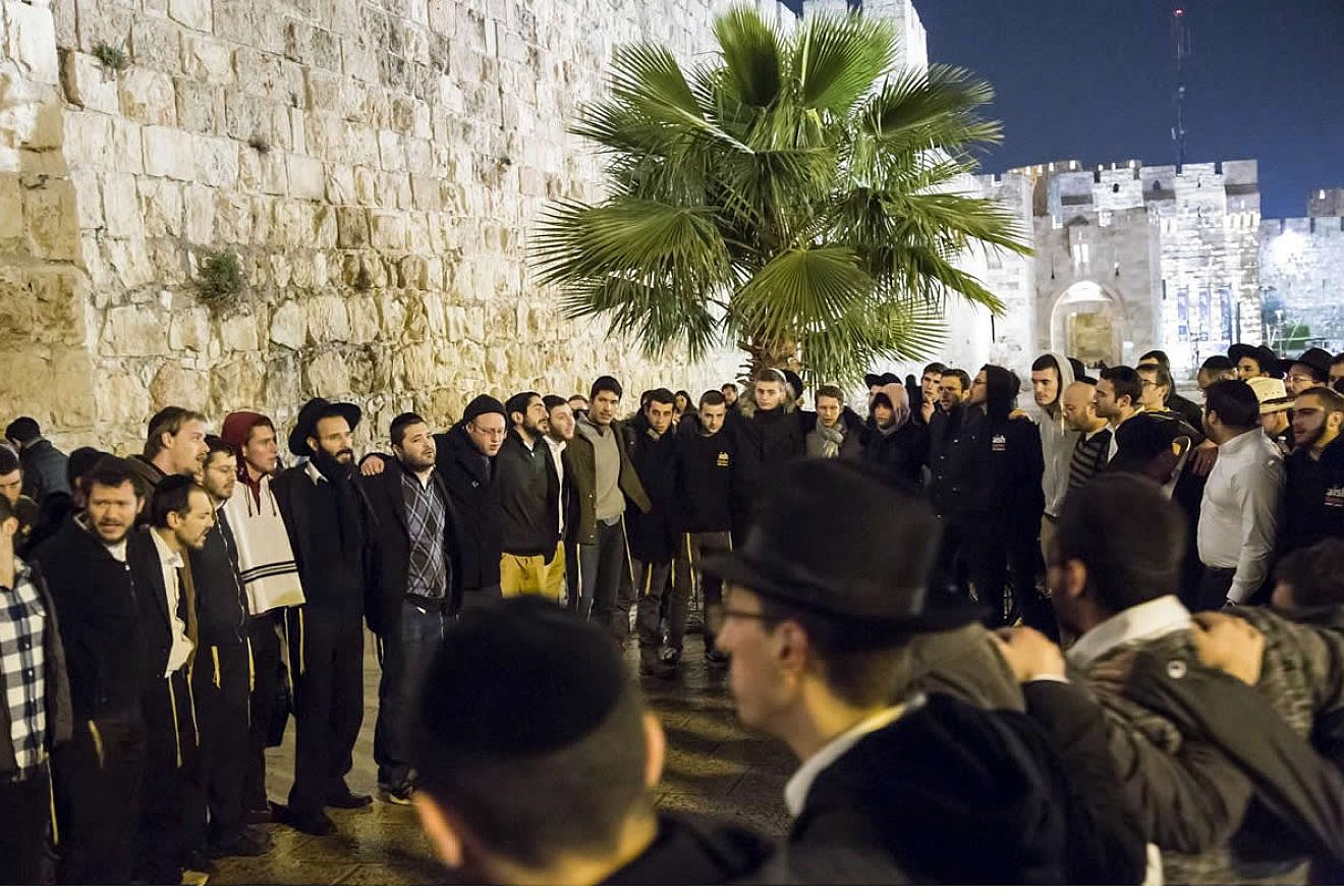 A group of students and rabbis sing “Acheinu” at the site outside the Jaffa Gate in Jerusalem where Rabbi Reuven Biermacher, 45, a husband and father of seven, was stabbed and killed by Palestinian terrorists on Dec. 23, 2015. Credit: Aish HaTorah.