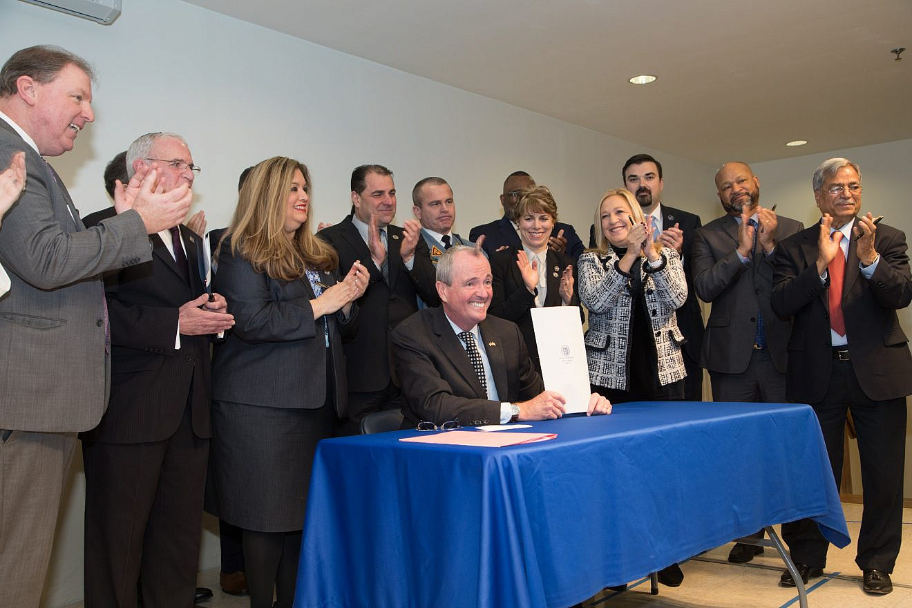 New Jersey Gov. Phil Murphy displays bill just signed into law on Jan. 8, 2019, that doubles funding for yeshivahs and other private schools. Credit: Mason Resnick/Teach N.J.