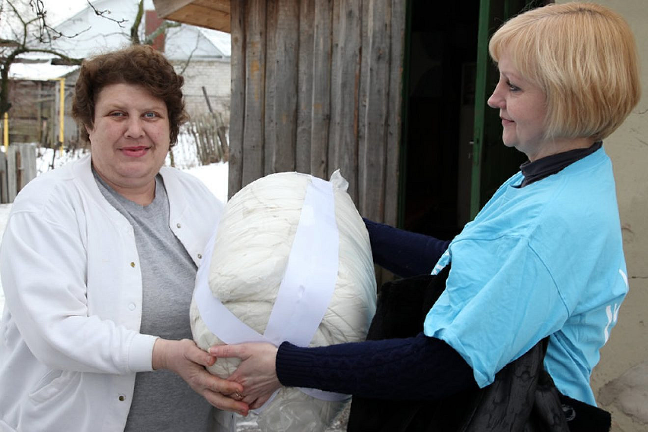 Warm bedding is delivered to Svetlana M. in Babruysk, Belarus, from a representative of the American Jewish Joint Distribution Committee’s Hesed Social Welfare Center. Credit: JDC.