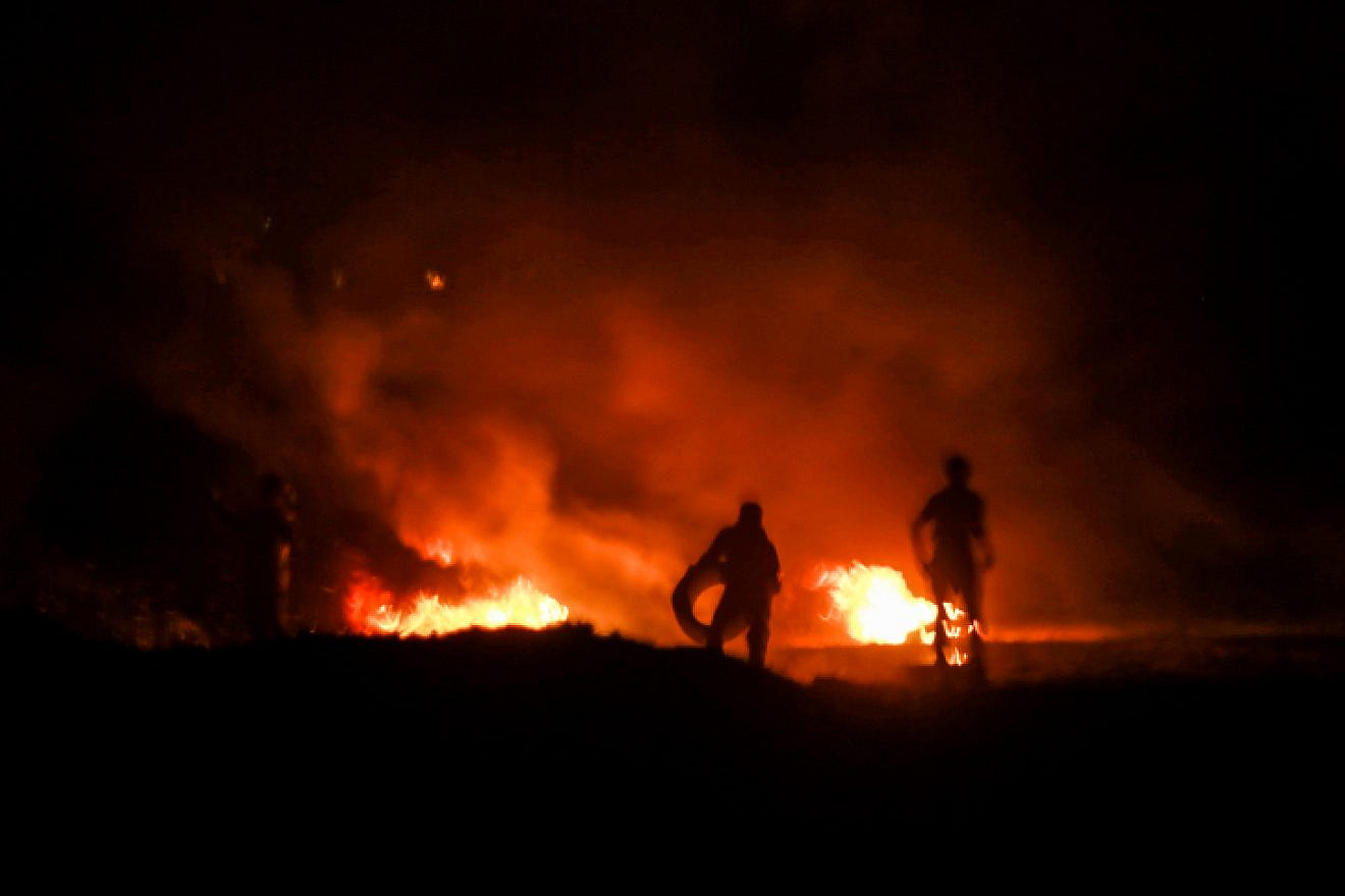 Palestinian protesters burn tires during a night protest near the border with Israel in the southern Gaza Strip, Feb. 14, 2019. Photo by Abed Rahim Khatib/Flash90.