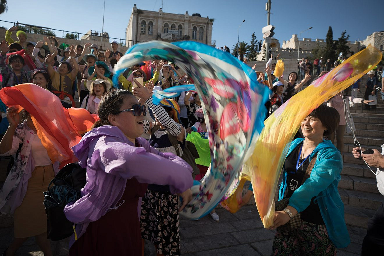 Asian tourists sing and celebrate outside the Damascus Gate in the Old City of Jerusalem on “Jerusalem Day” on May 24, 2017. Credit: Nati Shohat/Flash90.