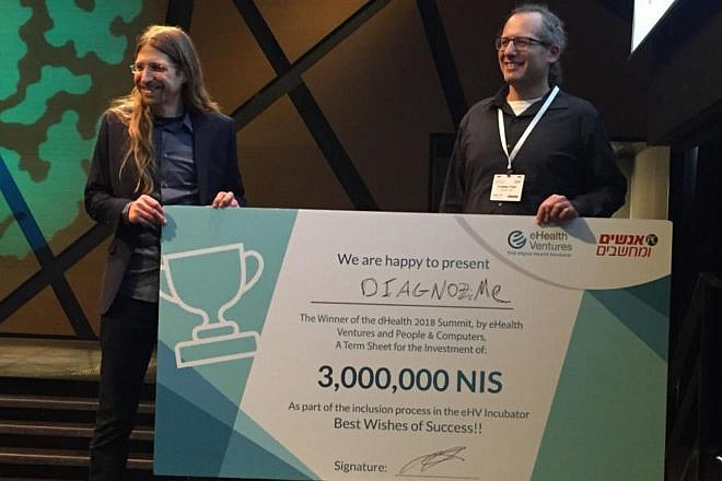 Diagnoz.me founders Ariel Livne and Tamir Epstein accepting their NIS 3 million (nearly $830,000) prize money at the dHealth 2018 Summit. Credit: Courtesy of Israel21c.