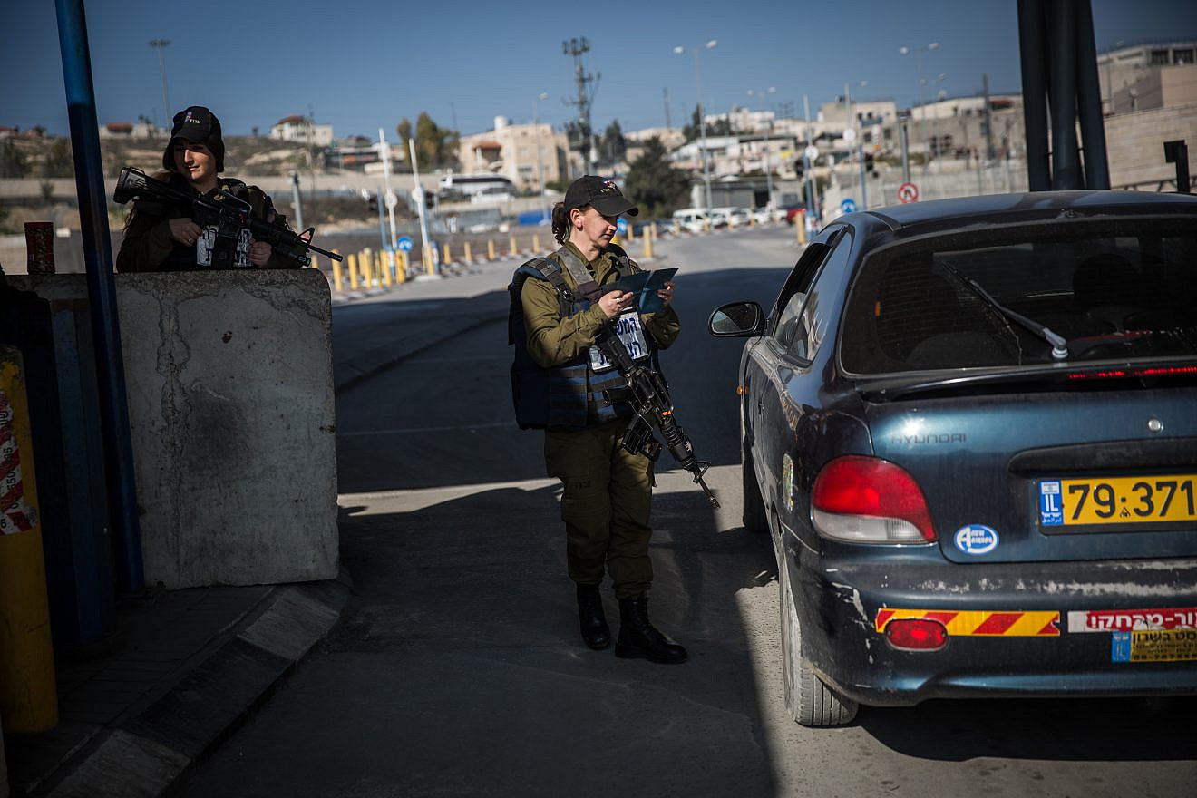 An Israeli soldier from the Erez Battalion checks IDs and Palestinian vehicles at the checkpoint to the Shuafat Refugee Camp in eastern Jerusalem on Dec. 22, 2015. Photo: Hadas Parush/Flash90.