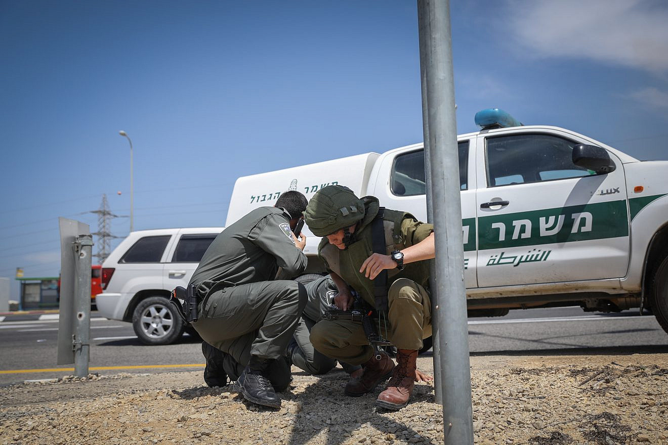 Israeli security forces take cover after hearing warning sirens on a road near the Gaza border on May 5, 2019. Photo by Noam Revkin Fenton/Flash90.