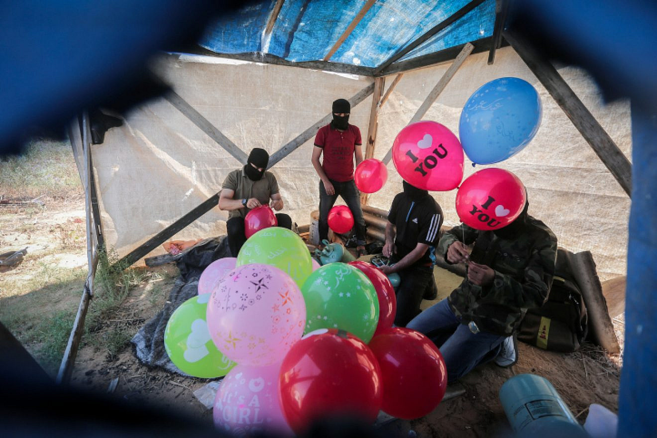 Palestinians prepare balloons that will be attached to flammable material to be launched into Israel from the Gaza Strip, on June 25, 2019. Photo by Hassan Jedi/Flash90.