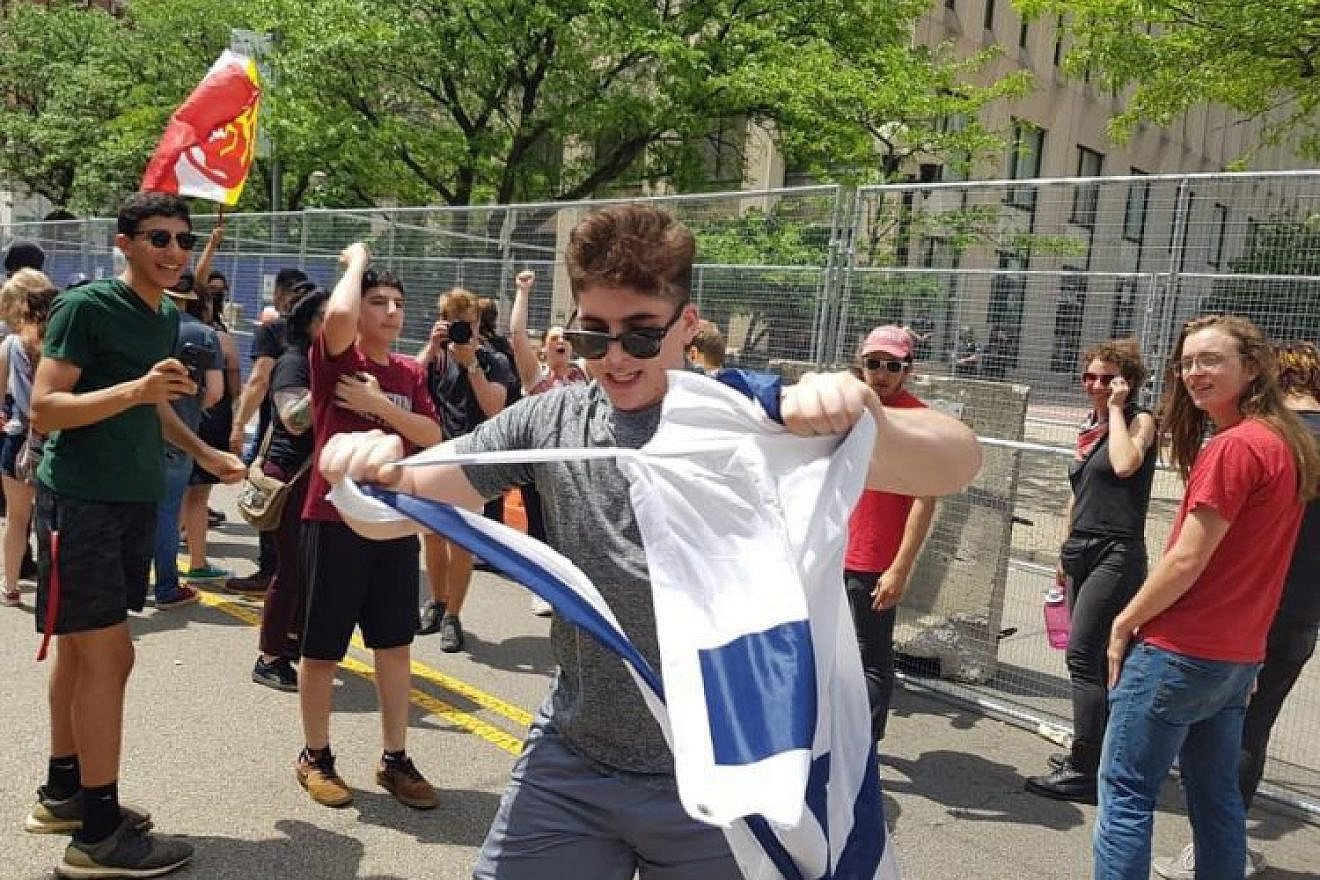 A counter-protester tears an Israeli flag on Third Street in Dayton next to Courthouse Square, the site of the Ku Klux Klan-affiliated Honorable Sacred Knights of Indiana's rally, May 25, 2019. Photo by Corine Fairbanks.