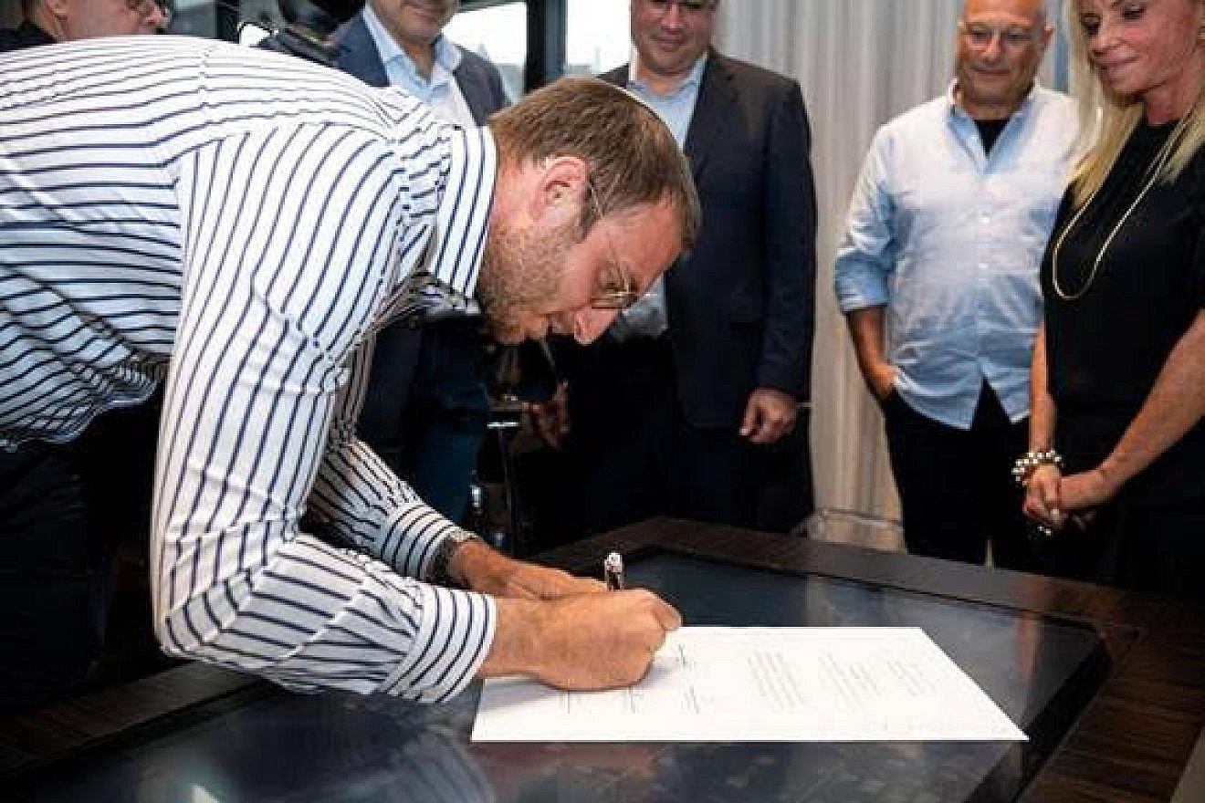 Mosaic United CEO Rabbi Benji Levy signs a partnership agreement with the leadership of UJA Federation of Greater Toronto to officialize the Toronto Jewish community’s investment in the Shalom Corps Jewish service initiative. Credit: Mosaic United.