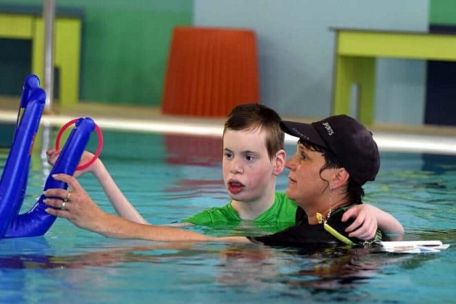 A hydrotherapist works with a resident with severe complex disabilities at the ALEH hydrotherapy pool in Jerusalem. Credit: ALEH.