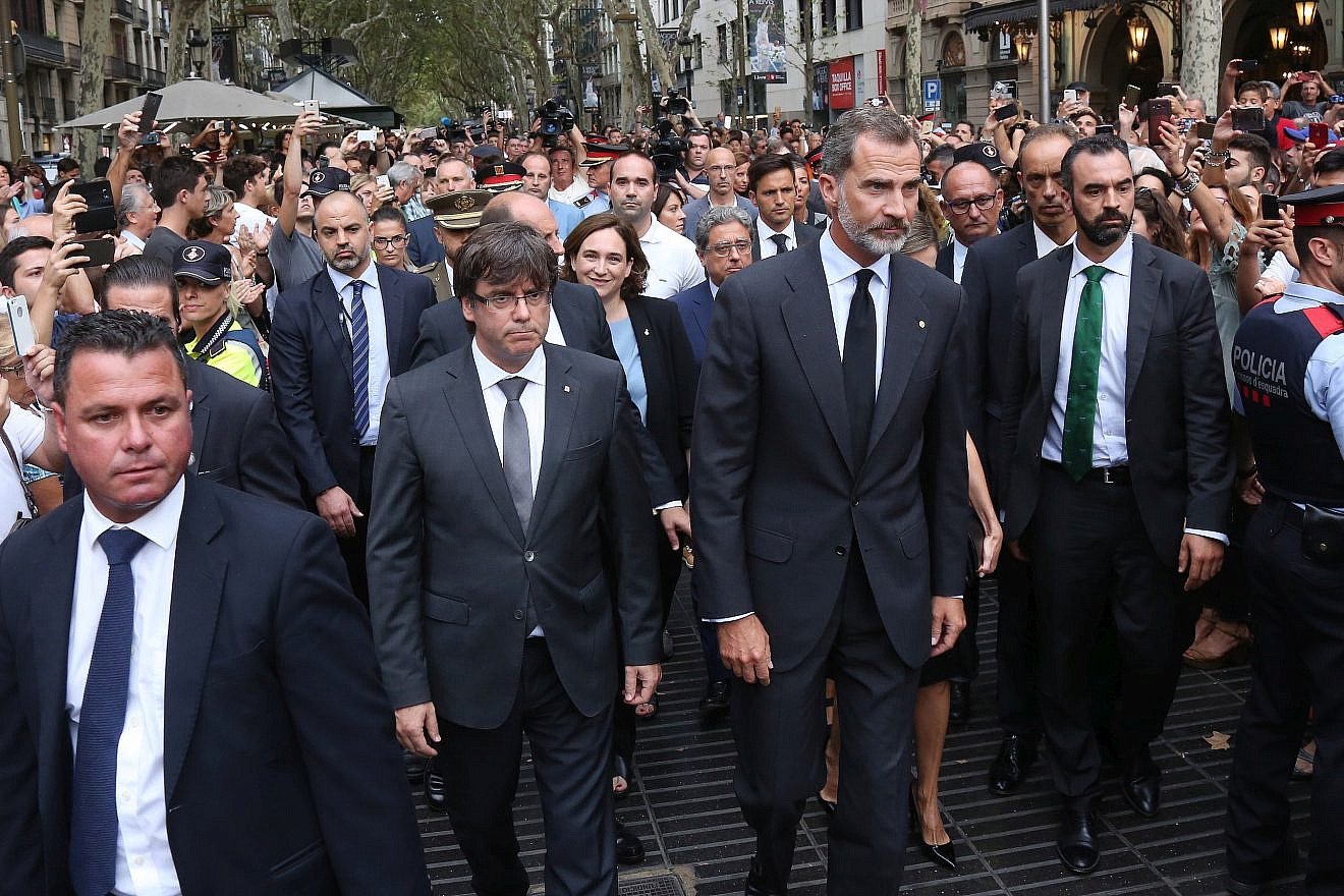 King Felipe VI of Spain (center), accompanied by Catalonia President Carles Puigdemont (left) and Barcelona Mayor Ada Colau, prepare to lay a wreath at the site of a truck-ramming attack two days earlier on La Rambla that left two people dead and more than 100 wounded, Aug. 19, 2017. Credit: Wikimedia Commons.