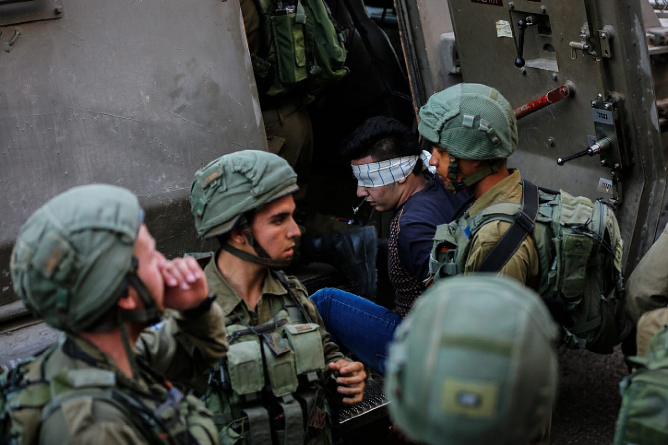 Illustrative: Israeli soldiers arrest a Palestinian man during raids in Hebron on Sept. 20, 2017. Photo by Wisam Hashlamoun/Flash90.