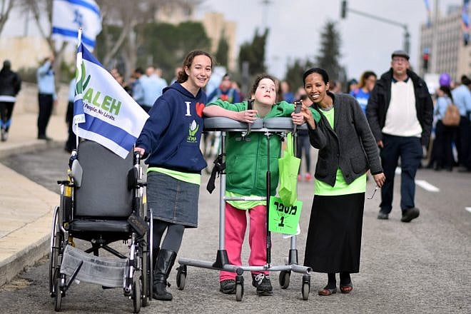 Volunteers and their young charge at a march for ALEH, Israel’s network of care for children with severe complex disabilities. Credit: Courtesy.