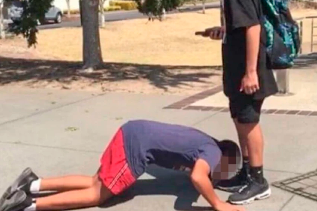 A photo of a 12-year-old Jewish boy in Australia being bullied to kiss the shoes of a Muslim classmate. Source: Twitter.